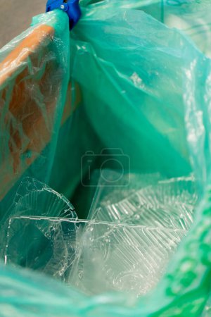 Foto de Primer plano de contenedores de plástico transparente se encuentran en una bolsa de basura en un recipiente de clasificación de plástico - Imagen libre de derechos