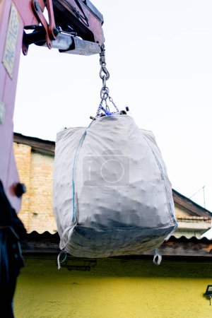 Foto de Una carretilla elevadora eleva una bolsa grande llena con una gran cantidad de botellas de vidrio usadas vacías para transportarlas para su reciclaje - Imagen libre de derechos