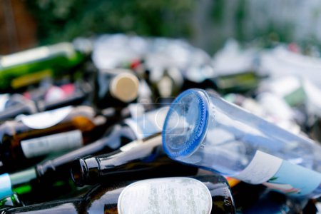 Téléchargez les photos : Gros plan sur les bouteilles en verre emballées dans un sac à ordures spécial à une station de recyclage des déchets pour leur élimination - en image libre de droit