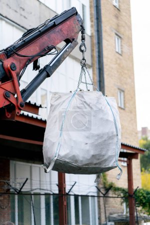 Téléchargez les photos : Un chariot élévateur soulève un grand sac rempli d'une énorme quantité de bouteilles en verre vides pour les transporter aux fins de recyclage - en image libre de droit