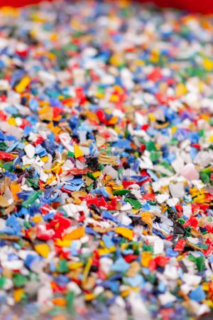 Photo for Close-up shot of shredded plastic caps stored in a special container at a waste recycling station - Royalty Free Image