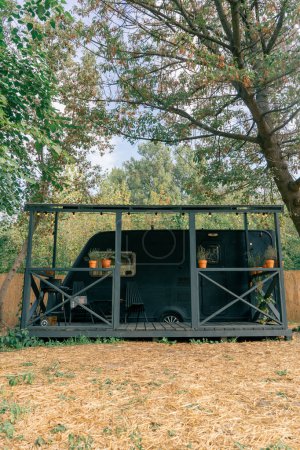 Téléchargez les photos : Un mobil-home avec terrasse est situé dans un site de glamping champêtre pour la détente et la solitude avec la nature - en image libre de droit