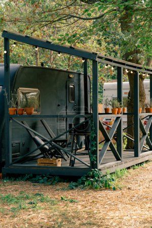 Foto de Una casa móvil con terraza se encuentra en un sitio de glamping país para la relajación y la soledad con la naturaleza - Imagen libre de derechos