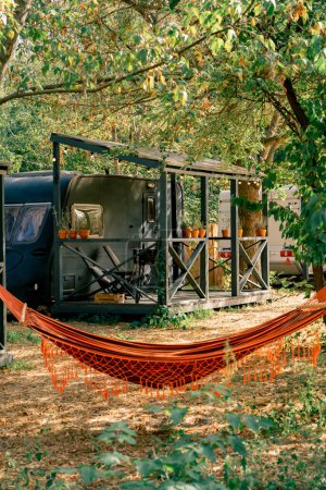 Téléchargez les photos : Un hamac attaché aux arbres sur le territoire des campings avec camping-cars pour le repos et la détente des voyageurs - en image libre de droit