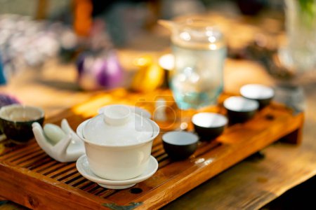 Téléchargez les photos : De petits bols fabriqués à la main à partir de céramique sont exposés en rangée sur un plateau en bois pour une cérémonie du thé - en image libre de droit