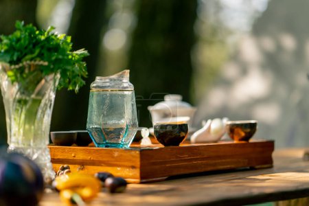 Téléchargez les photos : Un stand en bois avec des bols remplis d'eau et des tasses de thé se tient sur la table parmi les légumes et les légumes - en image libre de droit
