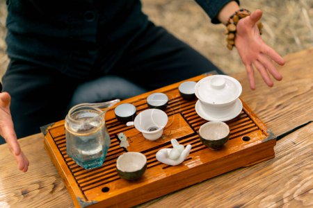 Téléchargez les photos : Un ensemble de bols et bols en céramique spéciaux est exposé sur une table en bois avec de l'eau bouillante pour une cérémonie du thé - en image libre de droit