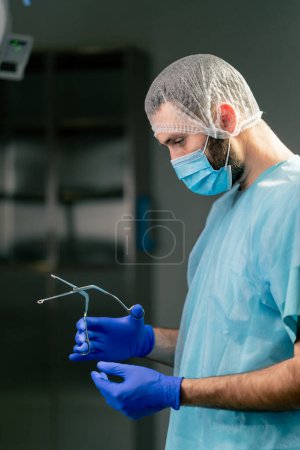Foto de Primer plano de un médico cirujano con un uniforme especial que prepara los instrumentos antes de la cirugía en un quirófano - Imagen libre de derechos