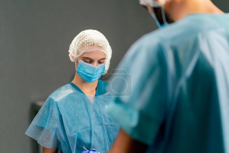Photo for The team of operating surgeons is focused on the correctness and accuracy of an operation for their patient - Royalty Free Image