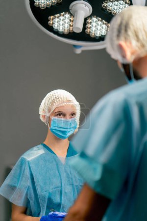 Photo for The team of operating surgeons is focused on the correctness and accuracy of an operation for their patient - Royalty Free Image