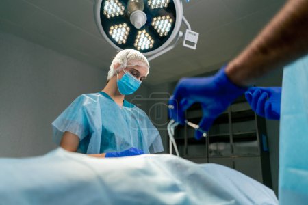 Foto de El equipo de cirujanos operados se centra en la corrección y precisión de una operación para su paciente. - Imagen libre de derechos