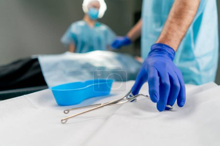 Photo for The operating surgeon takes a metal sterilized scalpel to begin the operation in the operating room - Royalty Free Image