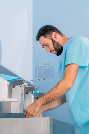 Photo for A doctor in medical uniform washes his hands under the tap and disinfects them with an antiseptic before work - Royalty Free Image