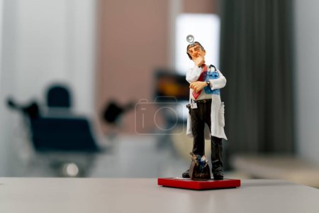 Photo for Close-up shot of a ceramic figurine of a doctor in a white coat with a frontal reflector on his forehead - Royalty Free Image