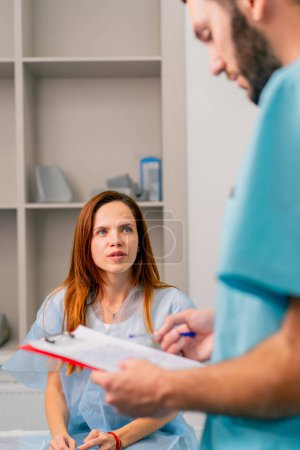 Photo for Close-up shot of a girl patient describing complaints about her condition and well-being to a radiologist before examination with an MRI - Royalty Free Image
