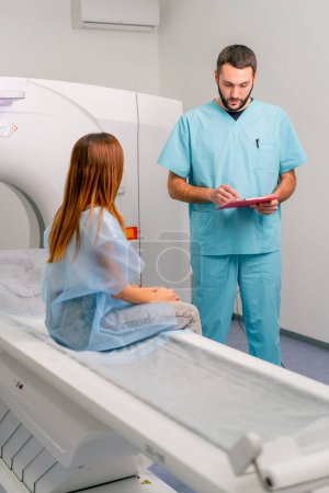Foto de Un radiólogo describe a una paciente los resultados de su examen después del diagnóstico mediante una máquina de resonancia magnética. - Imagen libre de derechos