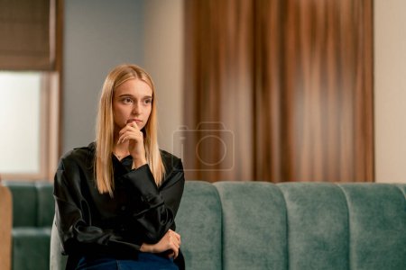 Photo for Portrait of a sad and worried girl in line in the hospital lobby before being examined and diagnosed - Royalty Free Image