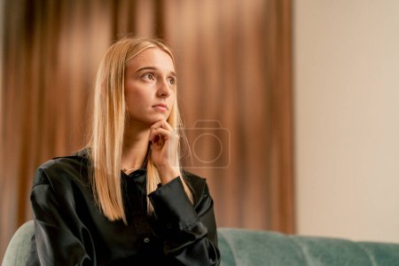 Photo for Portrait of a sad and worried girl in line in the hospital lobby before being examined and diagnosed - Royalty Free Image