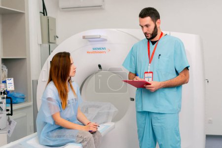 Foto de Un radiólogo consulta a una paciente antes de someterse a un diagnóstico utilizando una máquina de resonancia magnética en un centro médico - Imagen libre de derechos