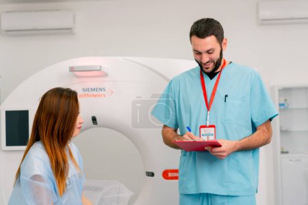 Photo for A radiologist describes to patient the results of her examination after diagnosis using an MRI machine - Royalty Free Image