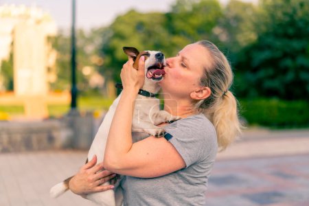 Téléchargez les photos : Portrait d'une femme tenant son petit chien de la race Jack Russell terrier soins animaux amitié - en image libre de droit