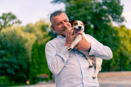Téléchargez les photos : Portrait d'un homme barbu adulte tenant son petit chien de la race Jack Russell Terrier animaux attentionnés amitié - en image libre de droit