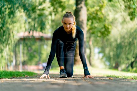 Téléchargez les photos : Une athlète professionnelle se prépare pour une course de vitesse lors d'un entraînement matinal dans le parc - en image libre de droit