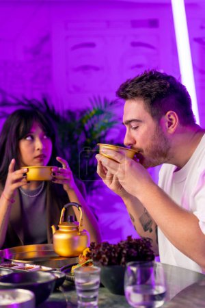 Téléchargez les photos : Un couple amoureux à une table déjeunant dans un restaurant coréen en buvant des makoli traditionnels - en image libre de droit