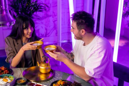 Téléchargez les photos : Un couple amoureux à une table déjeunant dans un restaurant coréen en buvant des makoli traditionnels - en image libre de droit