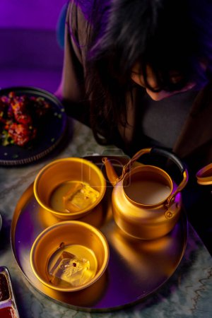 Foto de Primer plano servir tetera de oro y taza con hielo tradicional coreano refresco makoli en el restaurante - Imagen libre de derechos