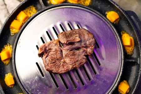 Téléchargez les photos : Gros plan de délicieux morceau juteux de viande grillée appétissante avec du fromage frit dans un restaurant coréen - en image libre de droit