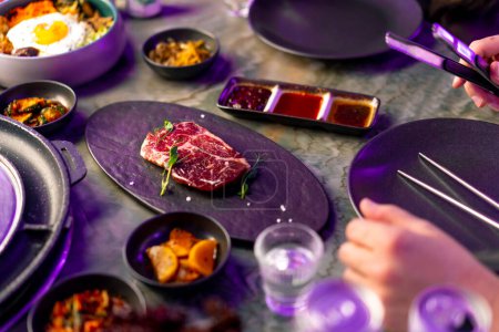 Foto de Primer plano vista superior delicioso apetitoso pedazo jugoso de mesa de carne cruda con salsas en los aperitivos en el restaurante coreano - Imagen libre de derechos