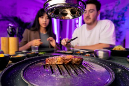 Téléchargez les photos : Gros plan de délicieux morceaux de viande crue appétissante et juteuse grillés dans un restaurant coréen - en image libre de droit