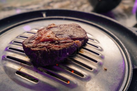 Téléchargez les photos : Gros plan de délicieux morceaux de viande crue appétissante et juteuse grillés dans un restaurant coréen - en image libre de droit