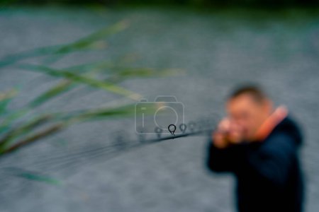 Photo for Portrait Fisherman with fishing rod spinning and professional tools sitting on the river bank sport fishing - Royalty Free Image