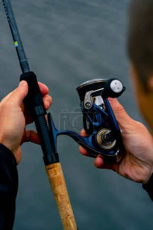 Foto de Close-up Fly pescador manos masculinas con caña de pescar girando en manos alimentador método de estilo libre - Imagen libre de derechos