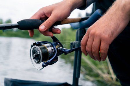 Photo for Close-up Fly fisherman male hands with fishing rod spinning in hands feeder free style method - Royalty Free Image
