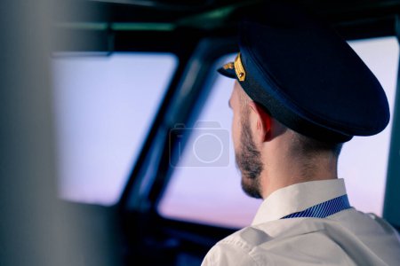 Téléchargez les photos : Portrait d'un pilote dans le poste de pilotage contrôlant l'avion pendant le transport par simulateur de vol en turbulence - en image libre de droit