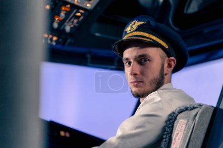 Photo for Portrait of serious airplane captain in uniform preparing flight in flight simulator cockpit - Royalty Free Image