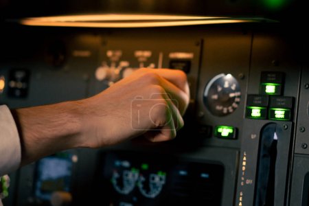 Téléchargez les photos : Main rapprochée du commandant de bord appuie sur les boutons du tableau de commande pour démarrer le moteur de l'avion simulateur de vol gros plan - en image libre de droit