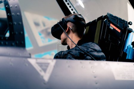 Photo for Boy sitting in flight simulator military plane wearing virtual reality glasses during flight entertainment - Royalty Free Image