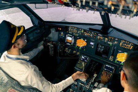 Téléchargez les photos : Cabine de l'avion Les pilotes vérifient l'électronique de l'avion en appuyant sur les boutons. - en image libre de droit