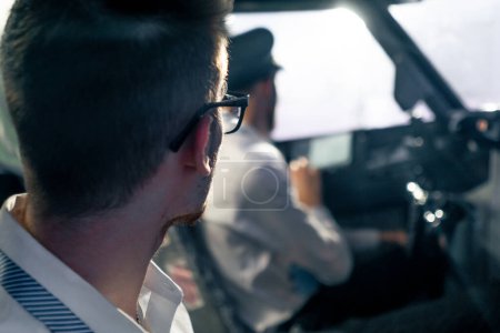 Téléchargez les photos : Jeunes pilotes dans le poste de pilotage du système de commande d'avion transport aérien pendant le simulateur de vol longue distance - en image libre de droit