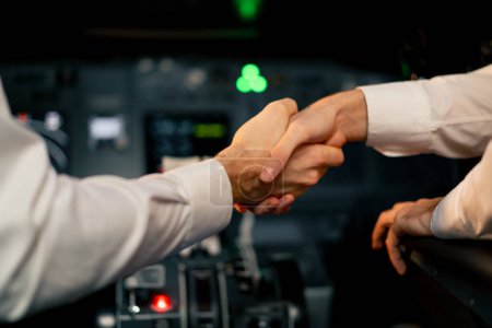 Photo for Pilots in the cockpit of the plane greet each other and shake hands before the start of flight close-up - Royalty Free Image