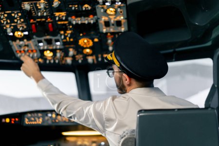 Téléchargez les photos : Cabine de l'avion Le pilote vérifie l'électronique de l'avion en appuyant sur les boutons Préparation du revêtement passager pour le décollage - en image libre de droit