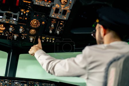 Téléchargez les photos : Cabine de l'avion Le pilote vérifie l'électronique de l'avion en appuyant sur les boutons Préparation du revêtement passager pour le décollage - en image libre de droit