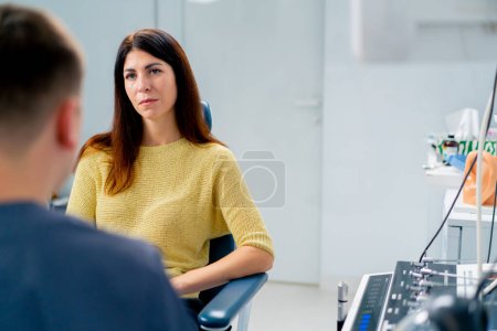 Photo for The ENT doctor consults the patient in the office of the clinic and tells about the possible consequences of operation - Royalty Free Image
