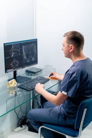 Foto de Un médico radiólogo examina una pantalla que muestra una imagen 3D de una exploración nasal para determinar los resultados de la cirugía plástica en la clínica - Imagen libre de derechos