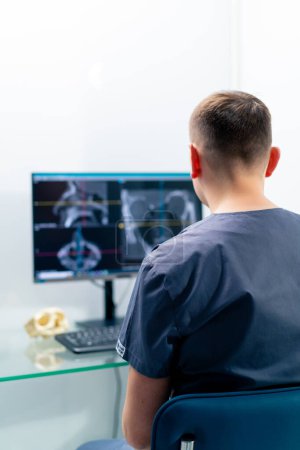 Téléchargez les photos : Un médecin radiologue regarde un écran montrant une image 3D d'un scanner de nez pour déterminer les résultats de la chirurgie plastique en clinique - en image libre de droit