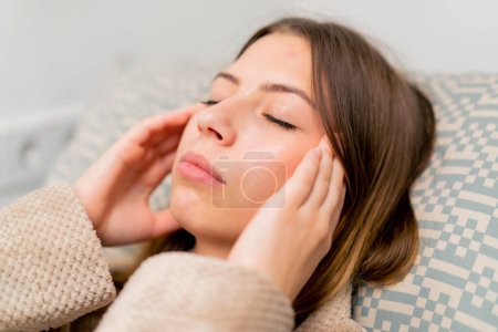 Téléchargez les photos : Un patient malade dans un hôpital est allongé sur un lit éternuant et souffrant de toux nasale et de maux de tête qui coulent - en image libre de droit
